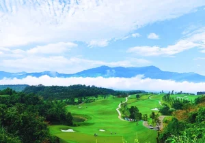Sapa Grand Golf Course in the valley near Lao Cai, with cloud and the mountains of Sa Pa behind