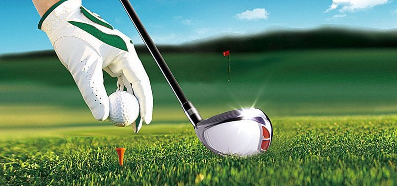 Beginner golfer placing golf ball on tee before a drive shot