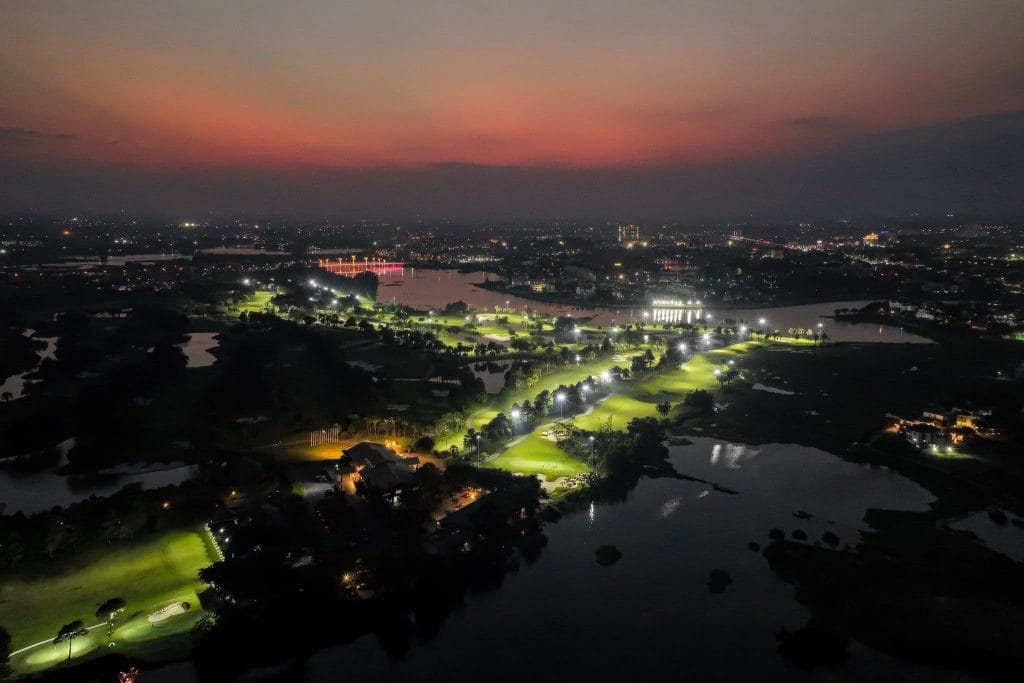 Heron Lake Golf Course & Resort fairways lit for night golf at dusk, beside Dam Vac Lake