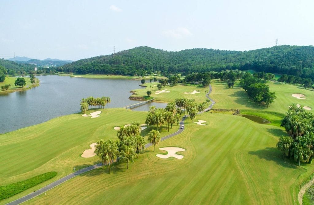 Chi Linh Star Golf & Country Club seen from above, showing the valley layout, lake and forested hills