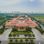 Aerial view of Long Bien Golf Course clubhouse in Hanoi with the city skyline behind it