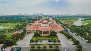 Aerial view of Long Bien Golf Course clubhouse in Hanoi with the city skyline behind it