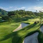 Silk Path Dong Trieu Golf and Country Club fairway with bunkers and forested hills