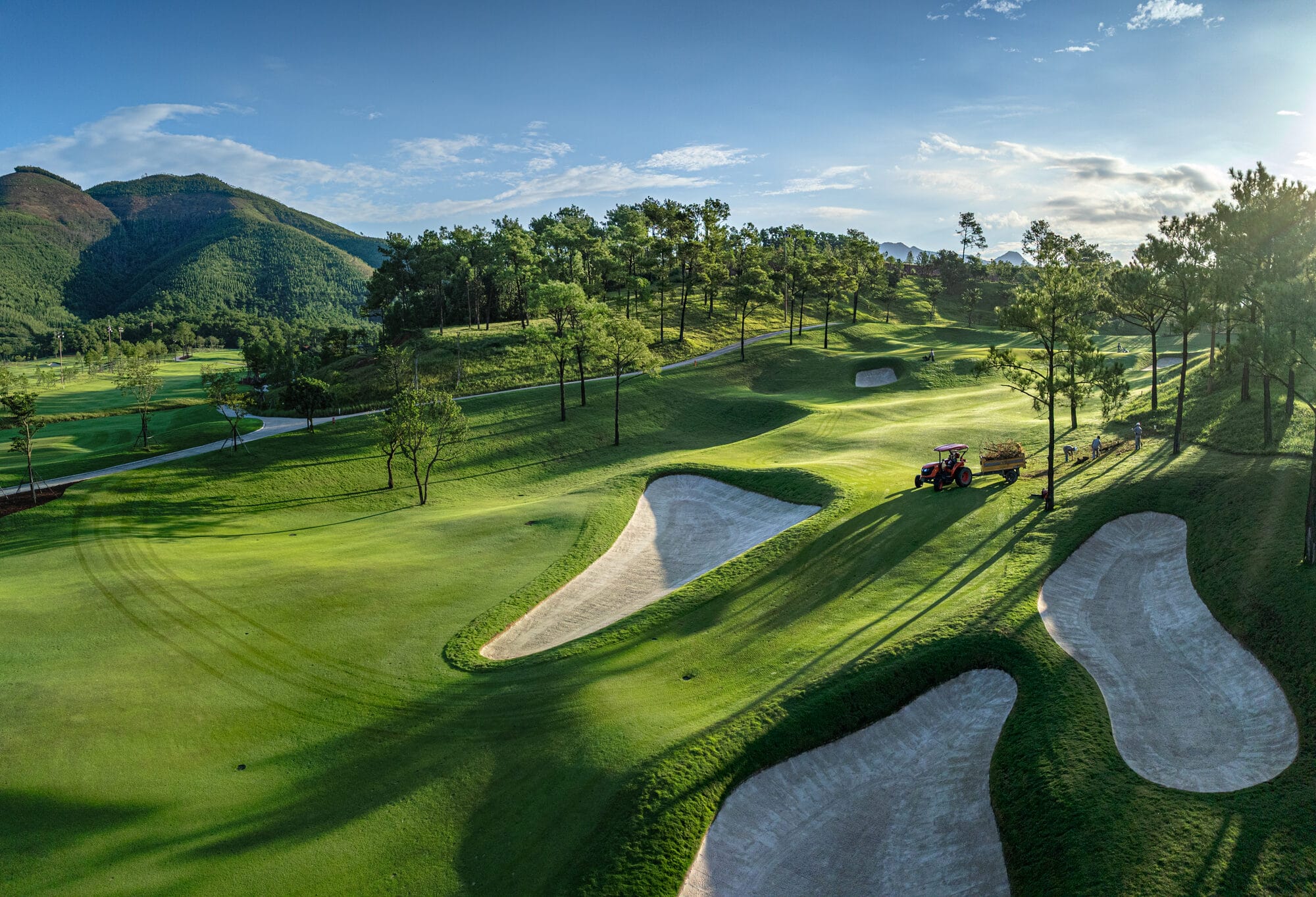 Silk Path Dong Trieu Golf and Country Club fairway with bunkers and forested hills