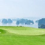 FLC Ha Long Bay Golf Club green with bunkers overlooking Ha Long Bay karsts