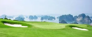FLC Ha Long Bay Golf Club green with bunkers overlooking Ha Long Bay karsts