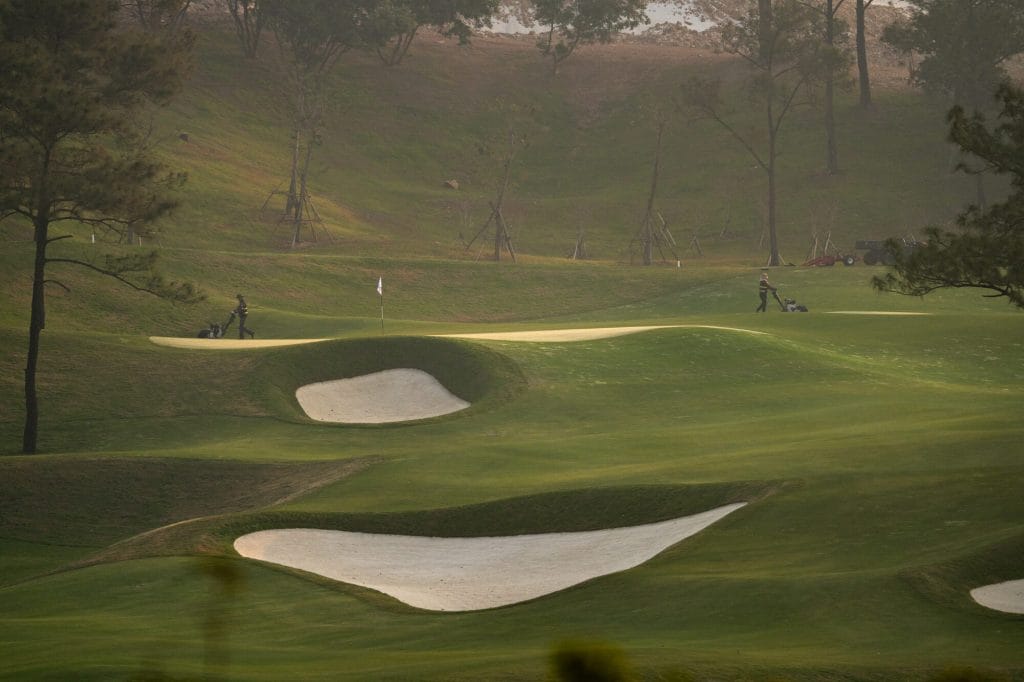 Silk Path Dong Trieu Golf and Country Club green framed by pine trees
