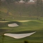 Silk Path Dong Trieu Golf and Country Club green framed by pine trees