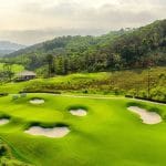 FLC Ha Long Bay Golf Club fairway framed by forested hills