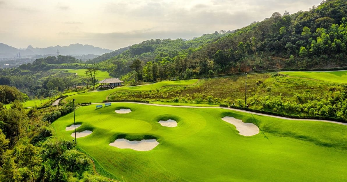 FLC Ha Long Bay Golf Club fairway framed by forested hills