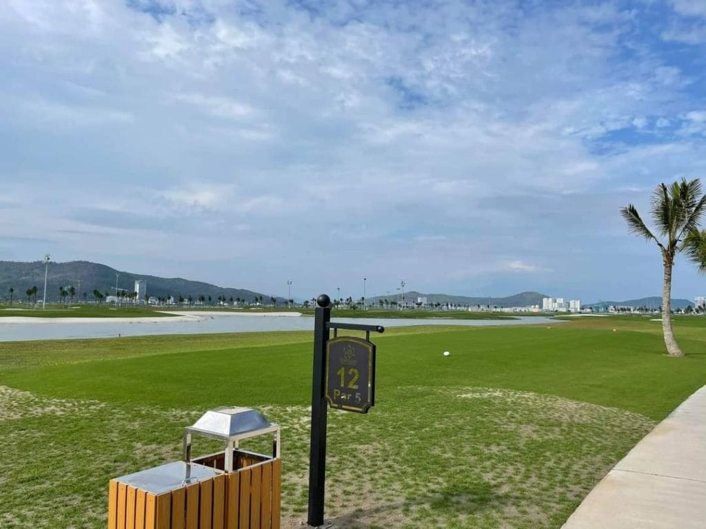 Tuan Chau Golf Resort coastal fairway with palm trees and golf cart