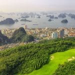 Aerial view of FLC Ha Long Bay Golf Club green with Ha Long Bay and Ha Long City in the background