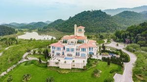 Aerial view of BRG Legend Hill Golf Resort clubhouse mansion surrounded by mountains near Hanoi