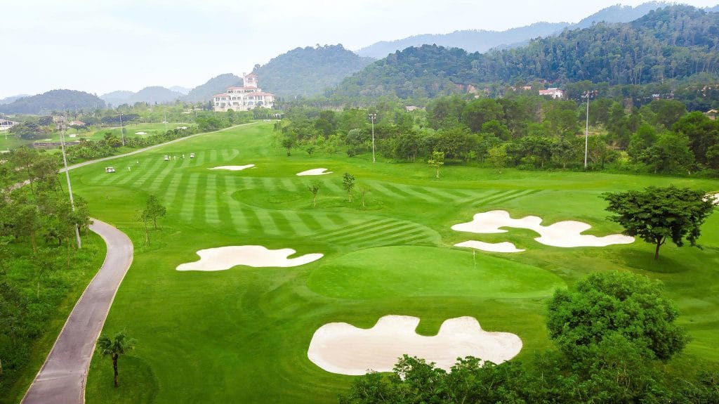 Island green with stone bridge at BRG Legend Hill Golf Resort, clubhouse in the background