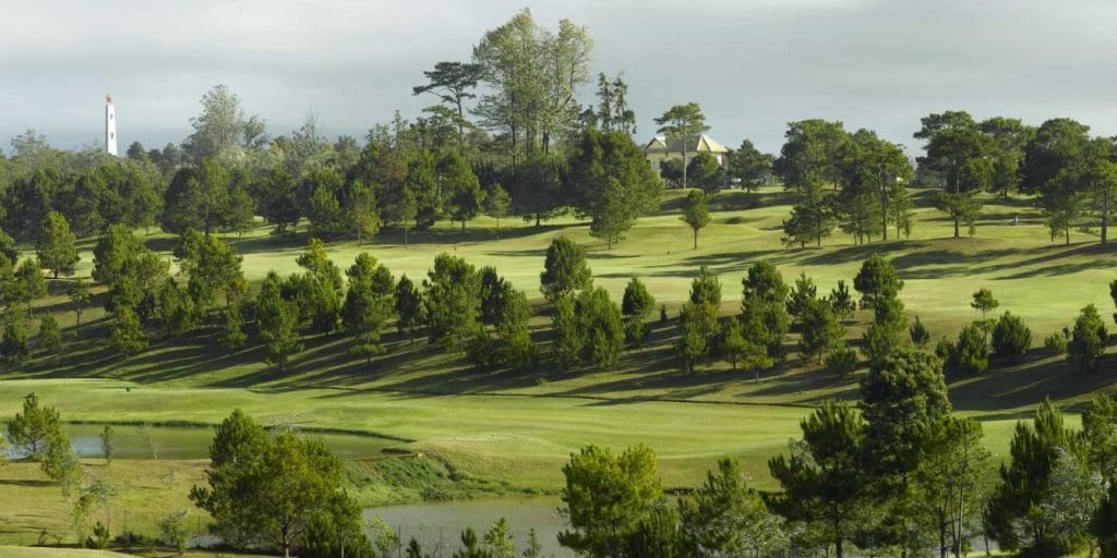 Dalat Palace Golf Club fairways lined with pines above a lake, Da Lat