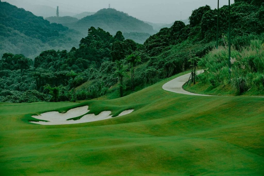 Sapa Grand Golf Course fairway and bunker below forested hills