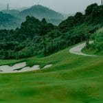 Sapa Grand Golf Course fairway and bunker below forested hills