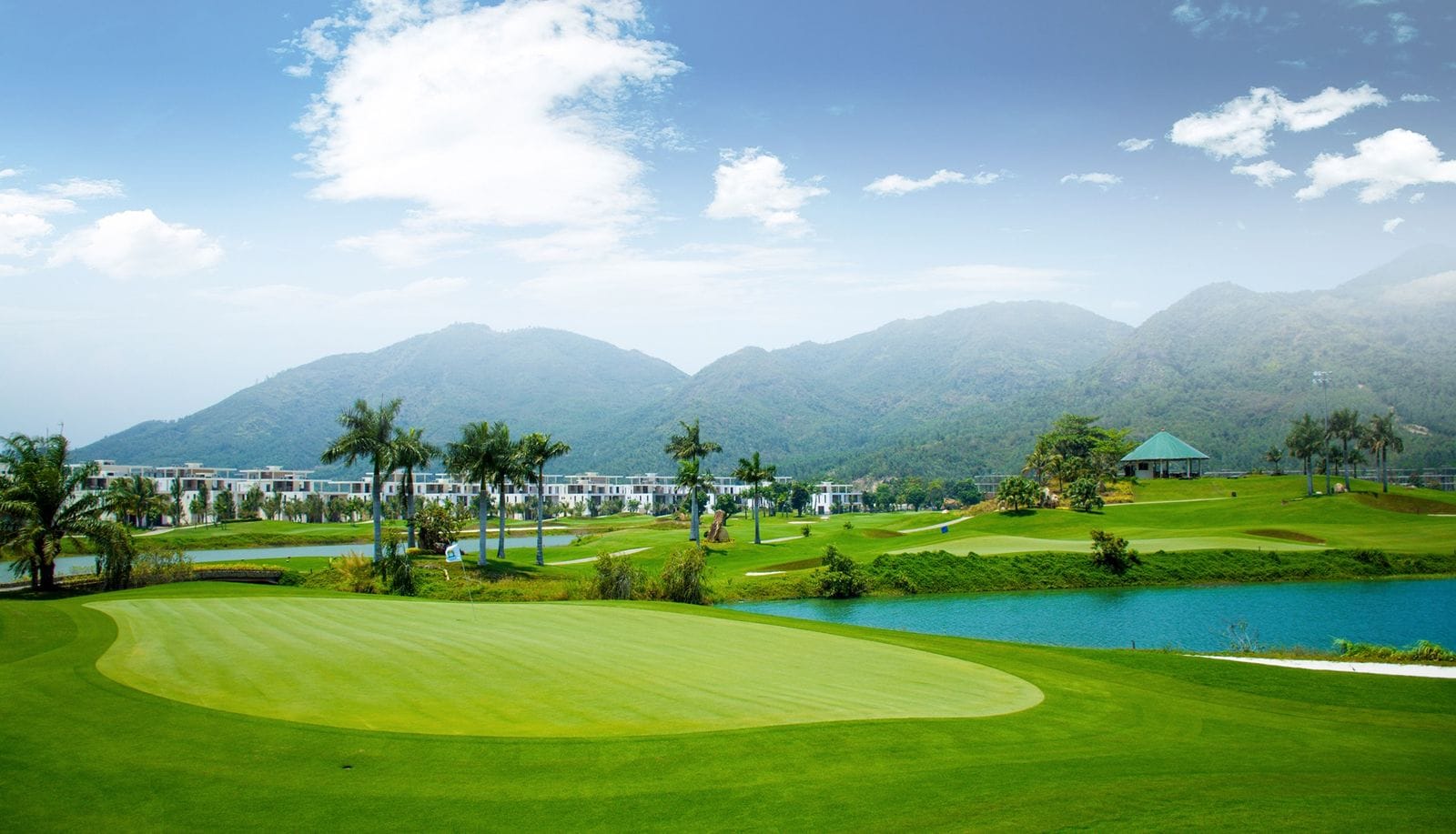 Lakeside green with mountains behind at Diamond Bay Golf & Villas