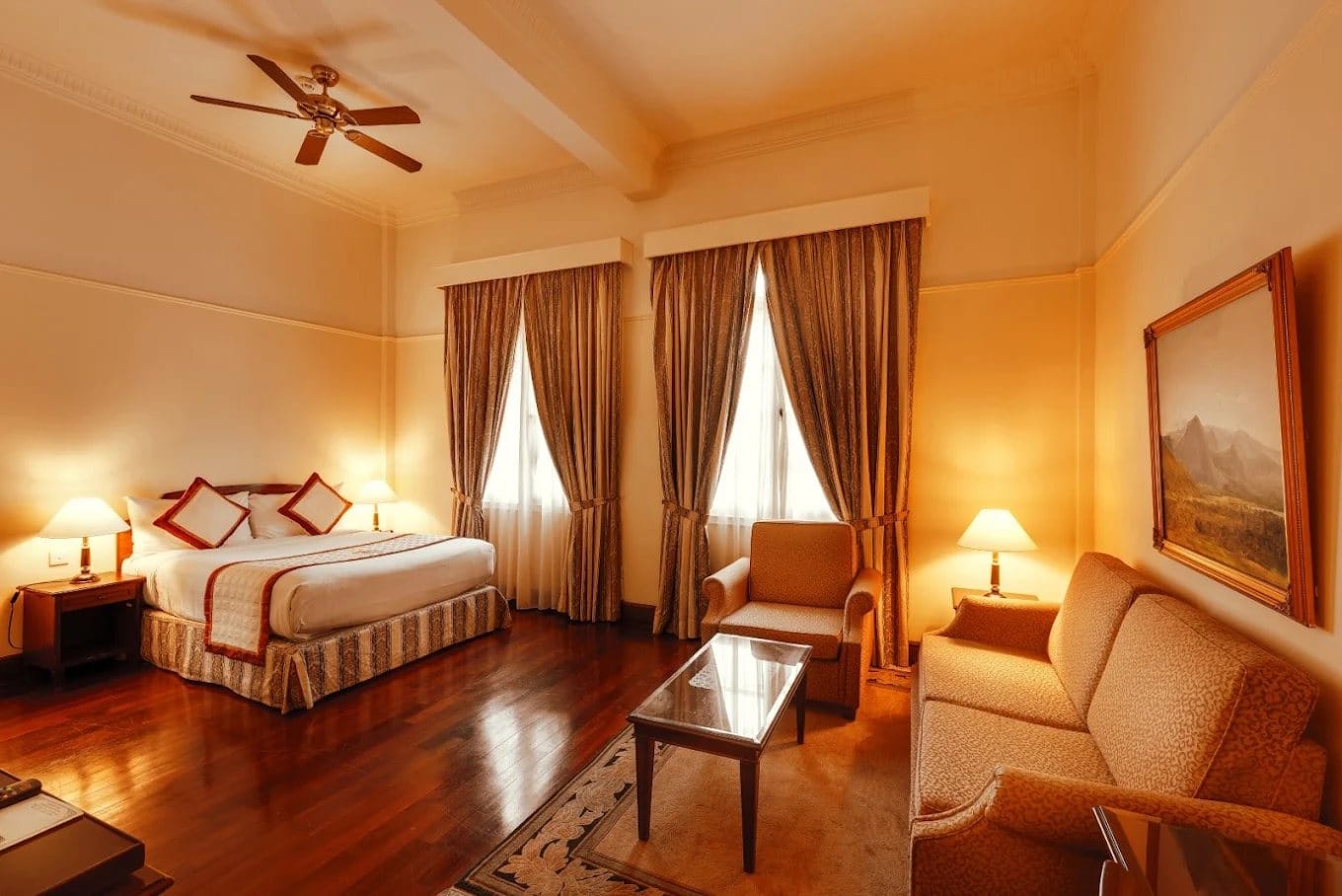 Guest room with wooden floor and sofa at Du Parc Hotel Dalat