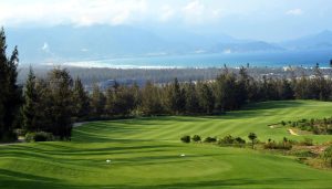 Tee shot on the FLC Quy Nhon Mountain Course with pine trees and the bay of Quy Nhon behind