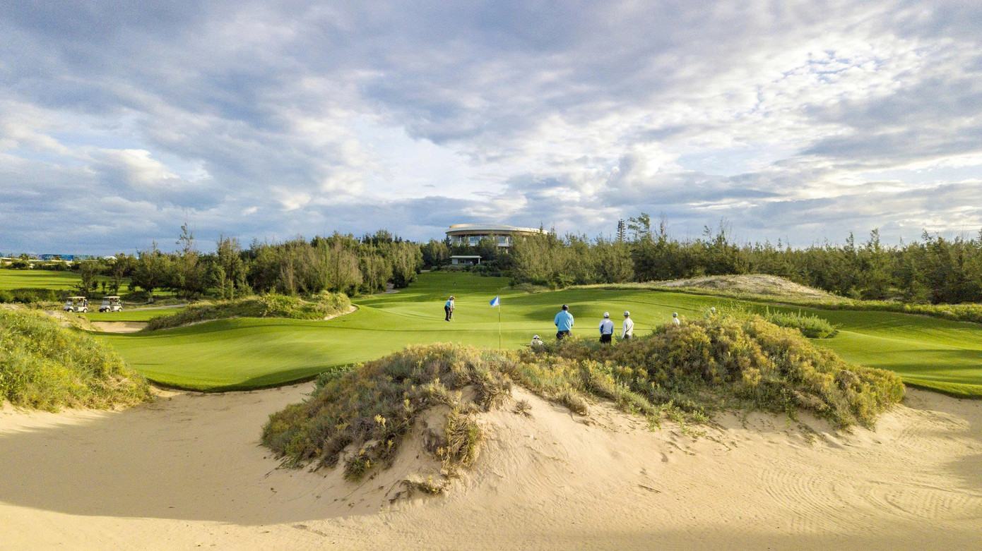 Fairway of the FLC Quy Nhon Ocean Course with mountains and the sea behind