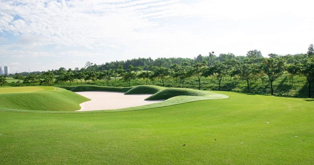 Green guarded by a large bunker at Harmonie Golf Park