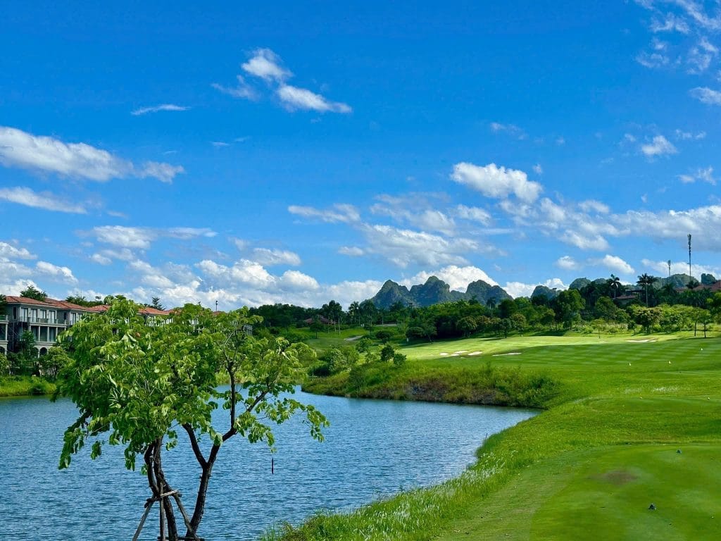Lakeside fairway at Sky Lake Resort & Golf Club near Hanoi, with limestone hills behind