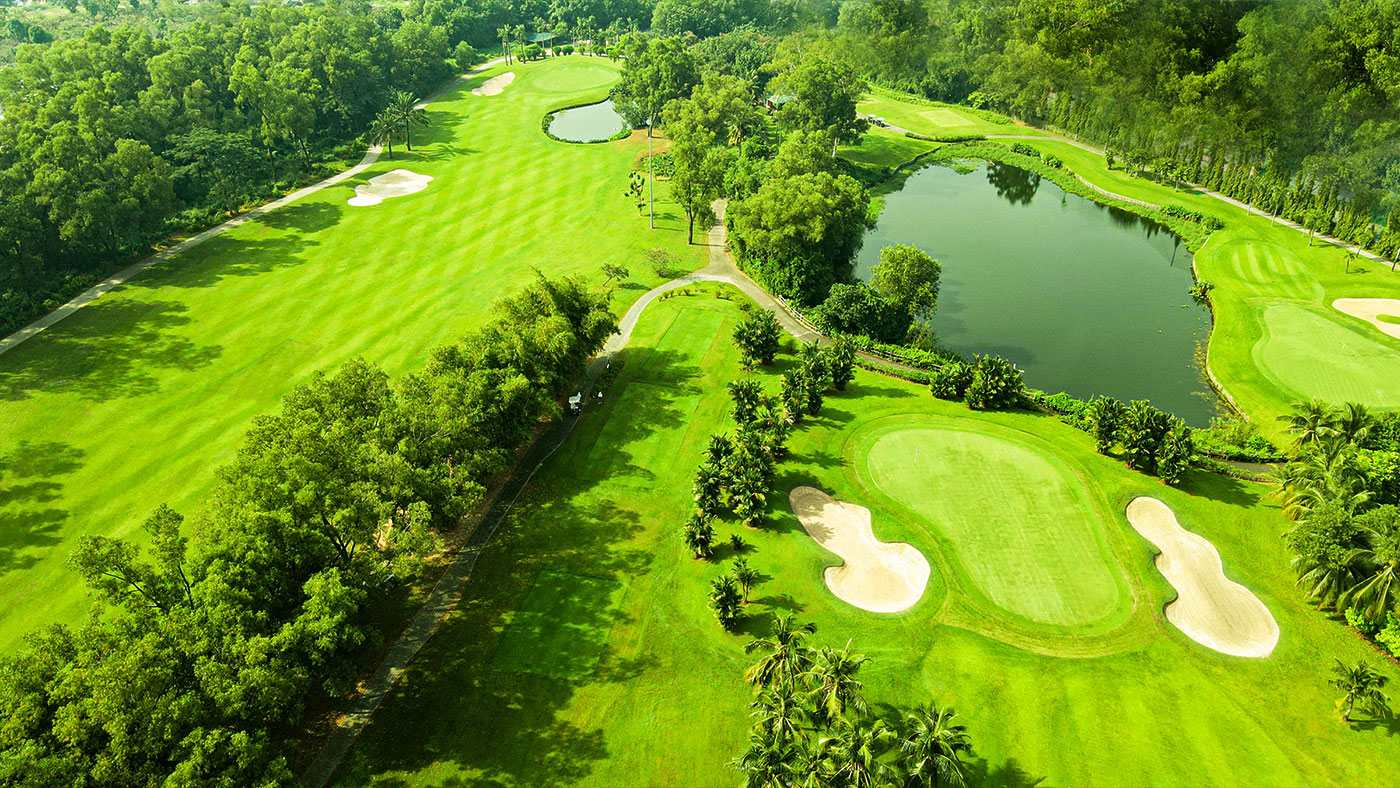 Green beside a lake at Song Be Golf Resort