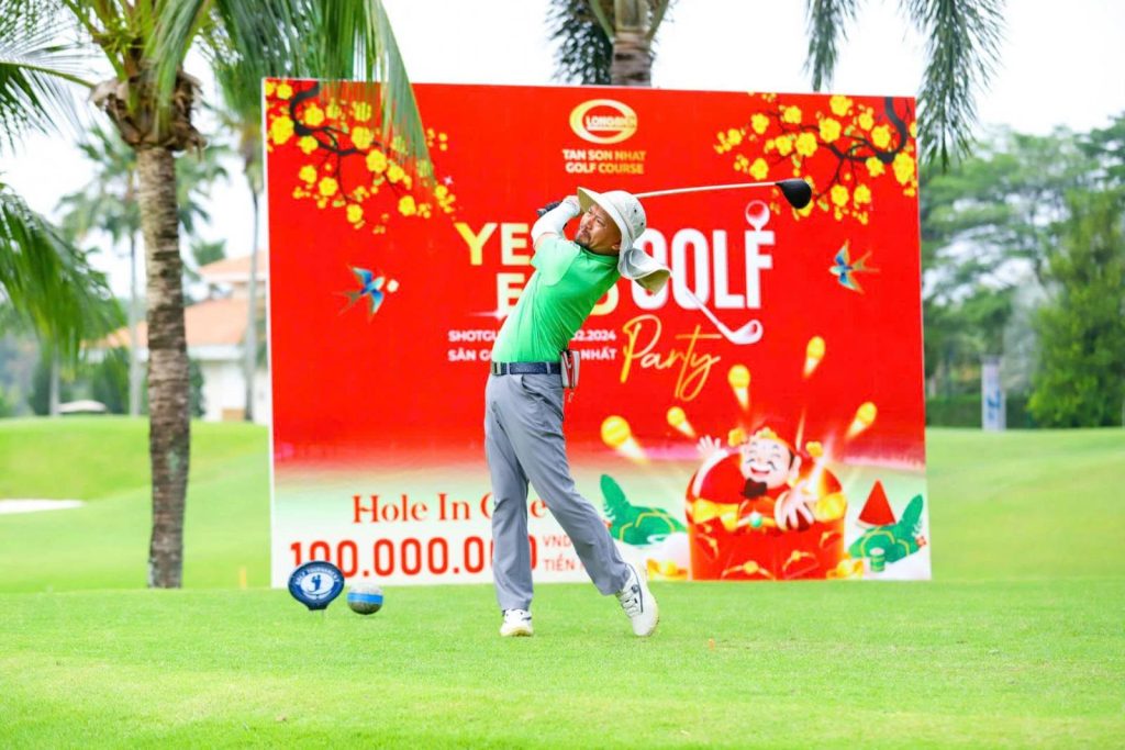 Golfer teeing off in front of a Lunar New Year banner at Tan Son Nhat Golf Course, Ho Chi Minh City
