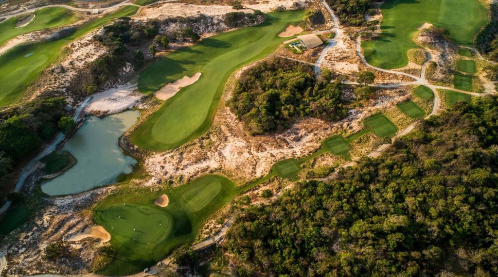 Fairways, a lake and greens set between sand dunes and forest at The Bluffs Grand Ho Tram