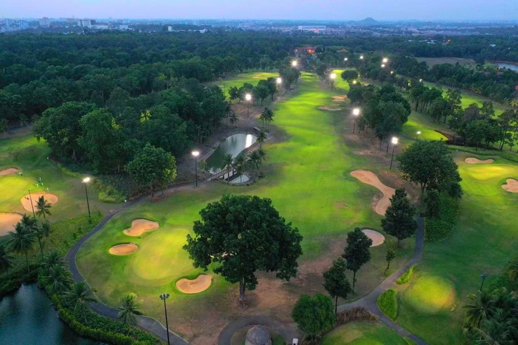 Aerial view of Vietnam Golf & Country Club fairways with the course lights on in the evening